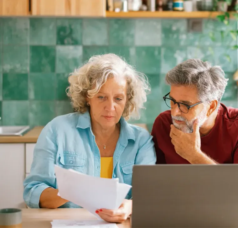 A couple at the kitchen table going through a statement together